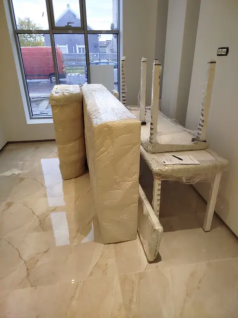 Upakovani delovi nameštaja na mermernom podu